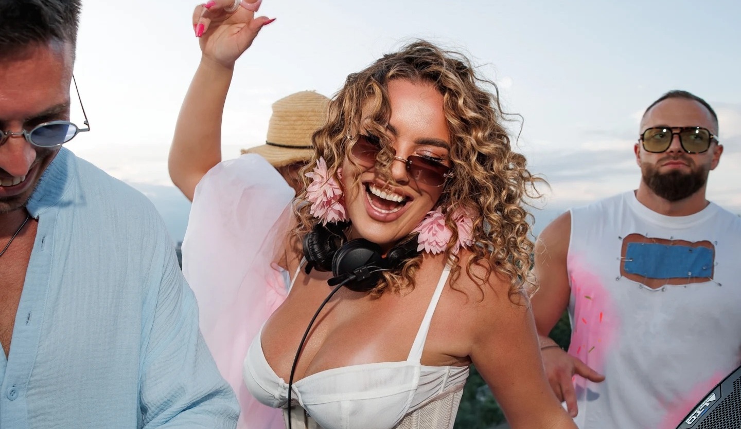 KSU laughing among dancers at a daytime rooftop party