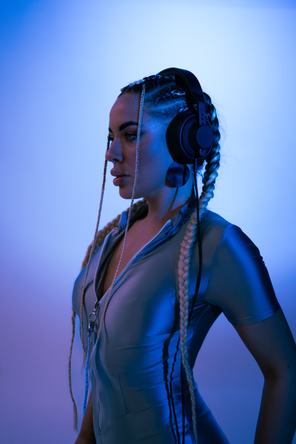 KSU in headphones and long braids under blue light