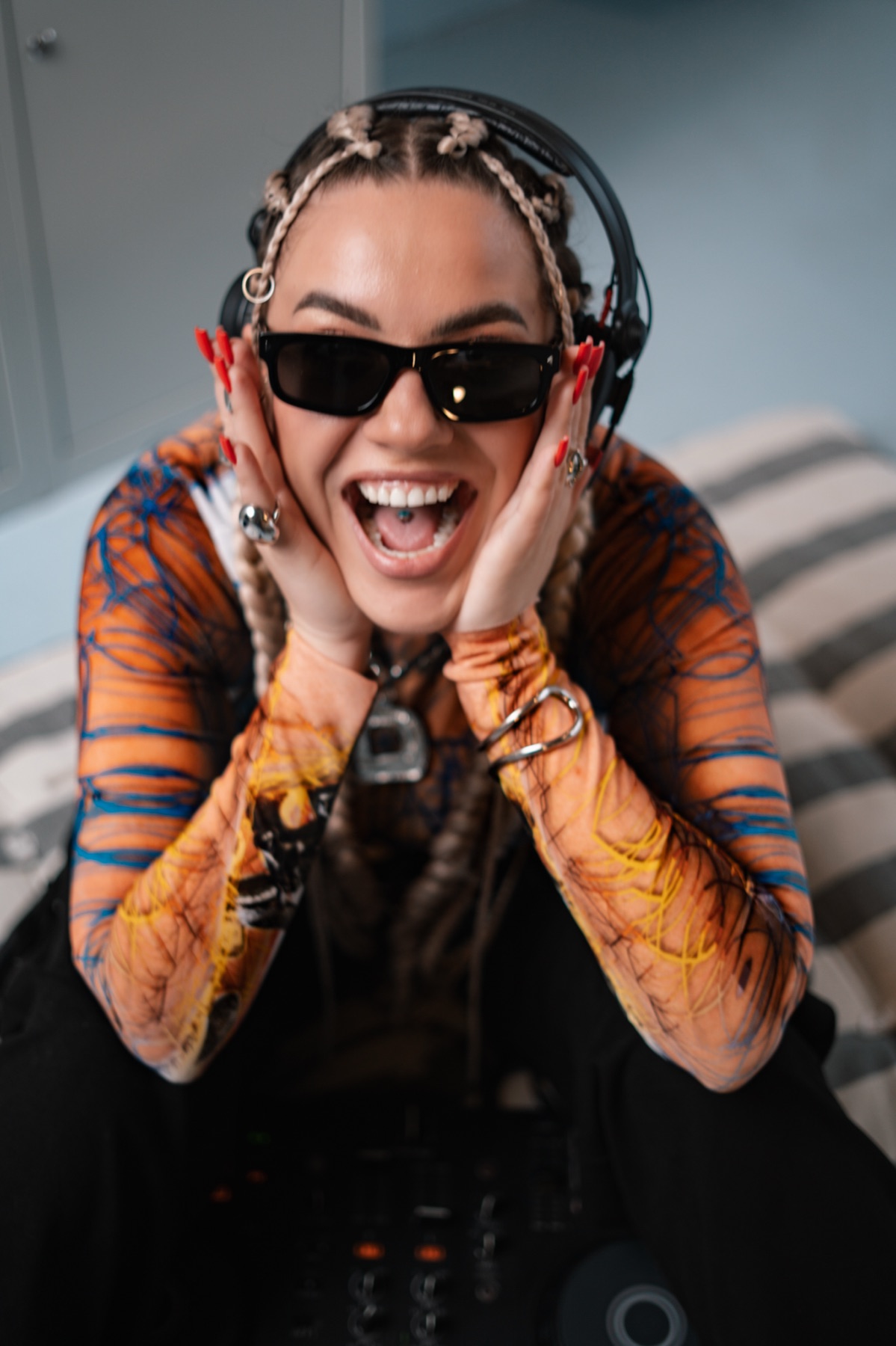 KSU laughing with her hands on her headphones