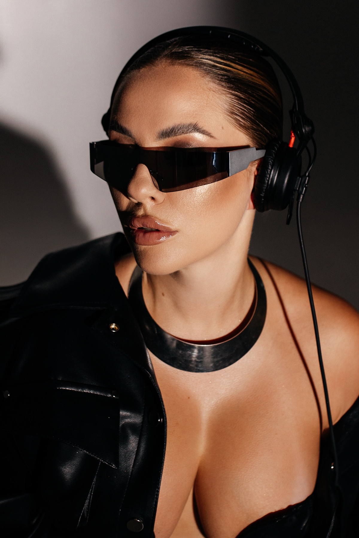 KSU in profile wearing headphones and dark glasses